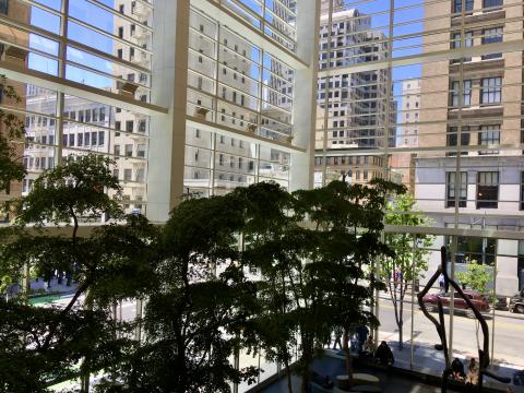 [Photo : hall d'un immeuble avec rue en transparence]